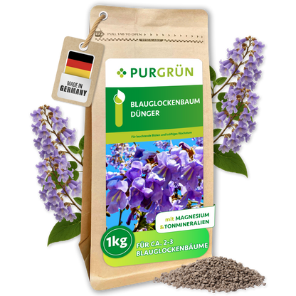Purgrün Blauglockenbaum-Dünger im 1-kg-Beutel, umrahmt von violetten Blüten und mit sichtbarem Düngerkorn.