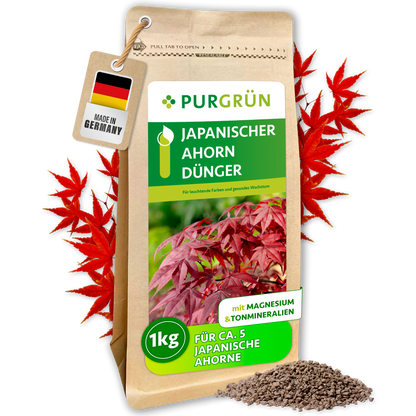 Purgrün Japanischer-Ahorn-Dünger im 1-kg-Beutel, umrahmt von roten Ahornblättern, mit Granulathaufen und „Made in Germany“-Anhänger.