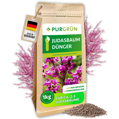 Purgrün Judasbaum-Dünger im 1-kg-Standbeutel mit sichtbarem Granulat und rosafarben blühendem Judasbaum.