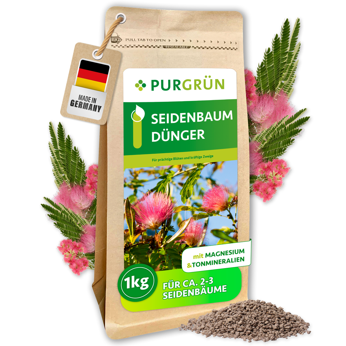 Purgrün Seidenbaum-Dünger, 1 kg, mit Magnesium und Tonmineralien, umgeben von rosa Seidenbaumblüten und Granulat.