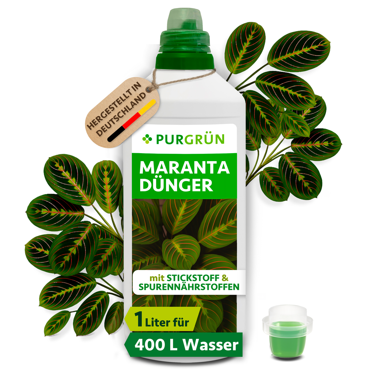 Purgrün Maranta-Dünger in der 1-Liter-Flasche mit Dosierkappe, umgeben von Maranta-Blättern und mit Anhänger „Hergestellt in Deutschland“.